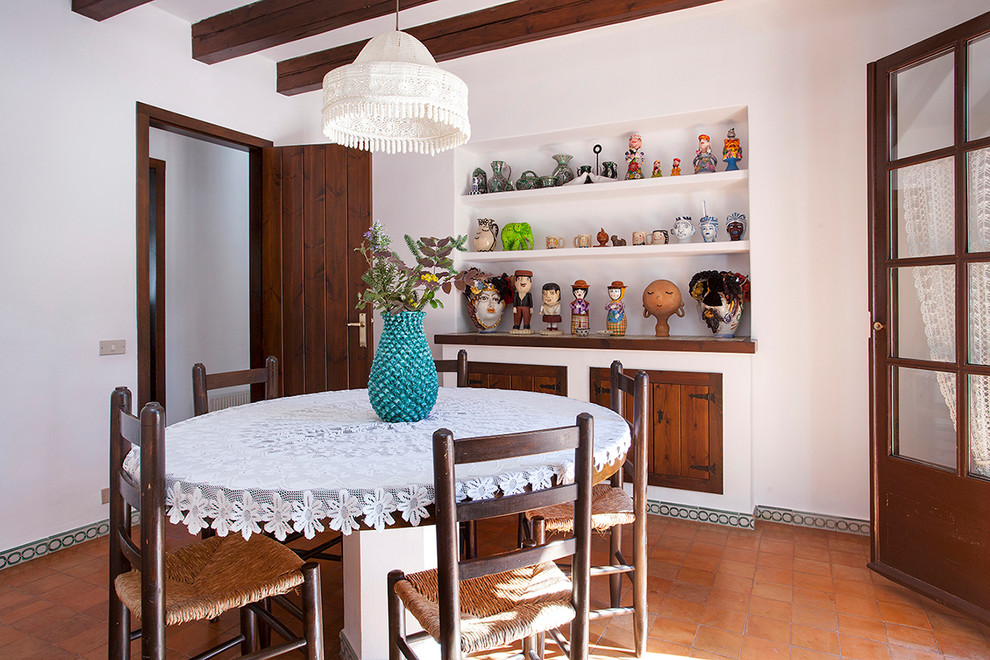 Diseño de comedor mediterráneo de tamaño medio cerrado sin chimenea con paredes blancas y suelo de baldosas de terracota