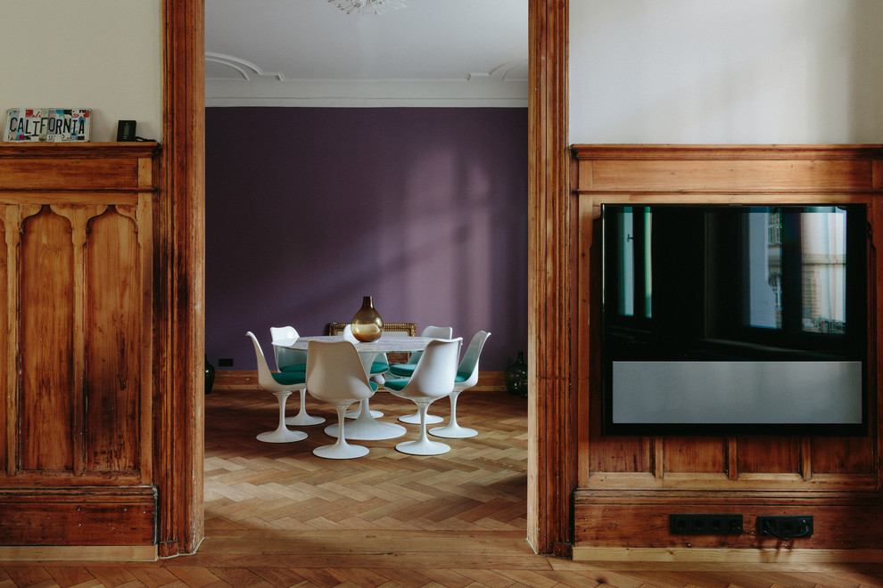 Idee per una sala da pranzo minimal con pareti viola, pavimento in legno massello medio e pavimento marrone