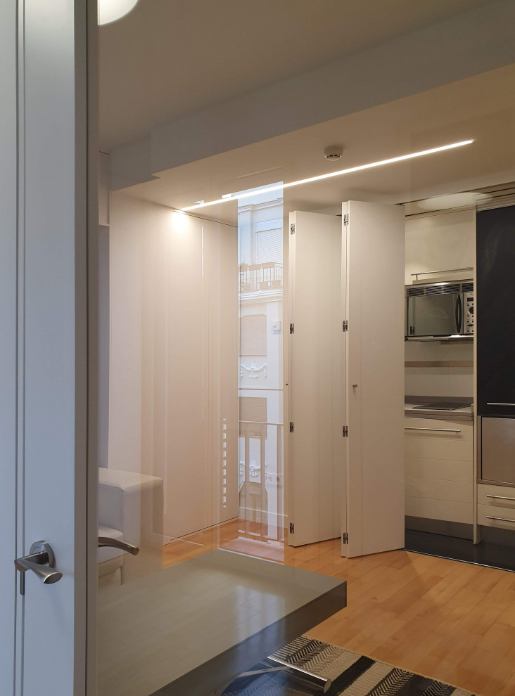 Inspiration pour une petite salle à manger ouverte sur la cuisine minimaliste avec un mur blanc, parquet clair et un sol marron.
