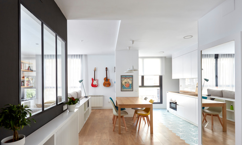 Diseño de comedor moderno de tamaño medio abierto con paredes blancas y suelo de madera clara
