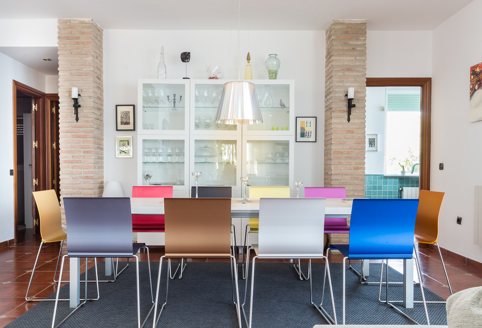 Ispirazione per una sala da pranzo mediterranea con pareti bianche e pavimento marrone