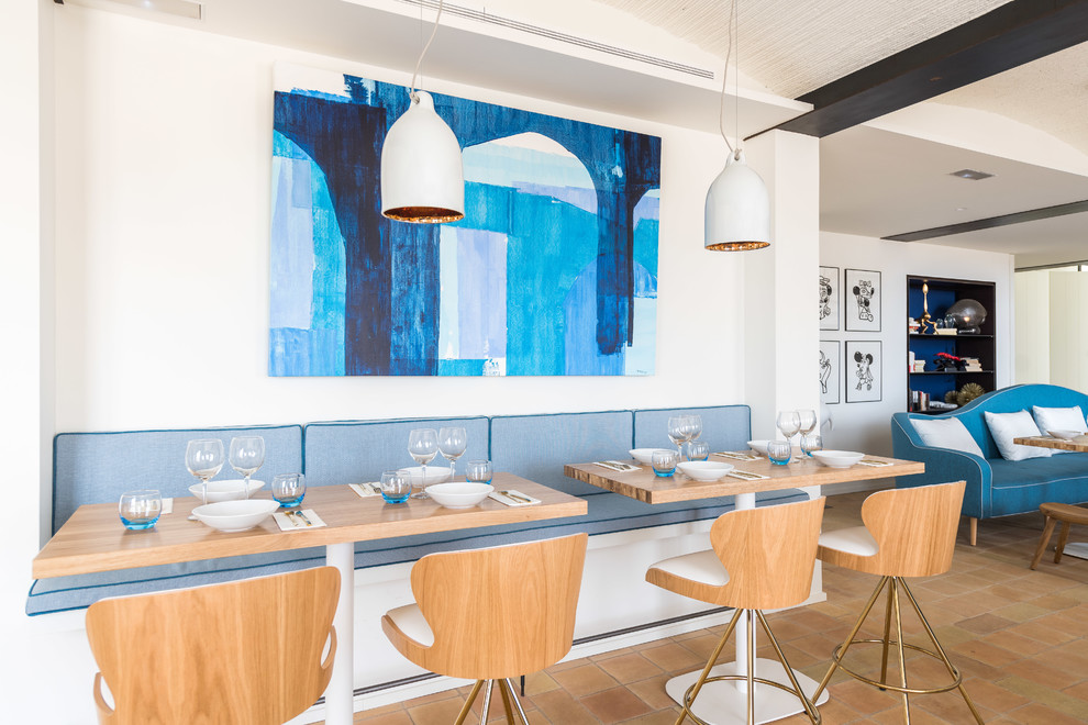 Foto di una sala da pranzo design con pareti bianche e pavimento marrone