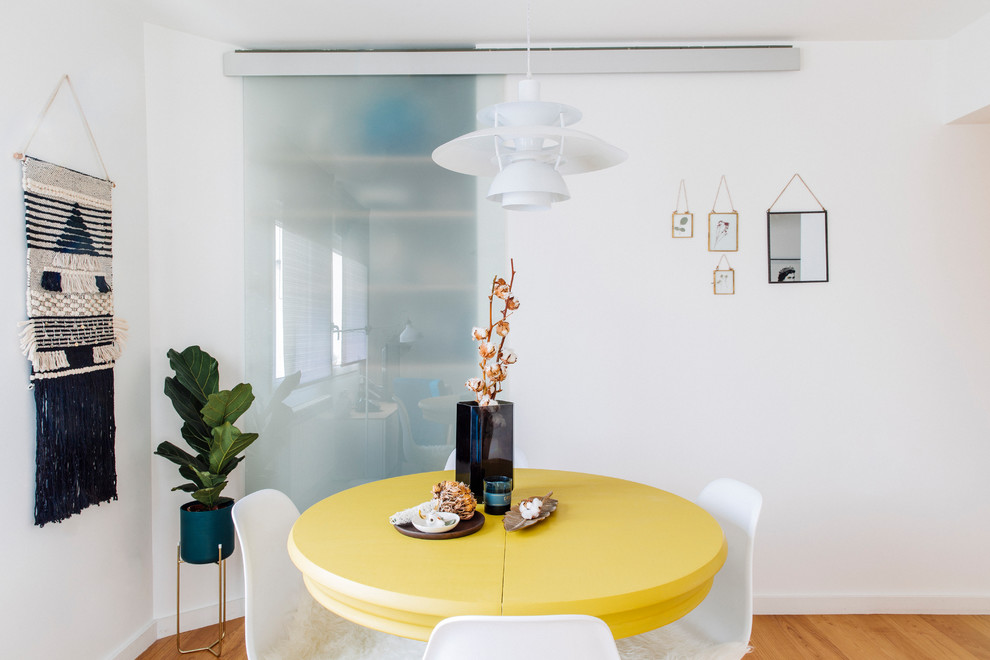 Esempio di una piccola sala da pranzo aperta verso la cucina tropicale con pareti bianche, pavimento in legno massello medio e pavimento marrone