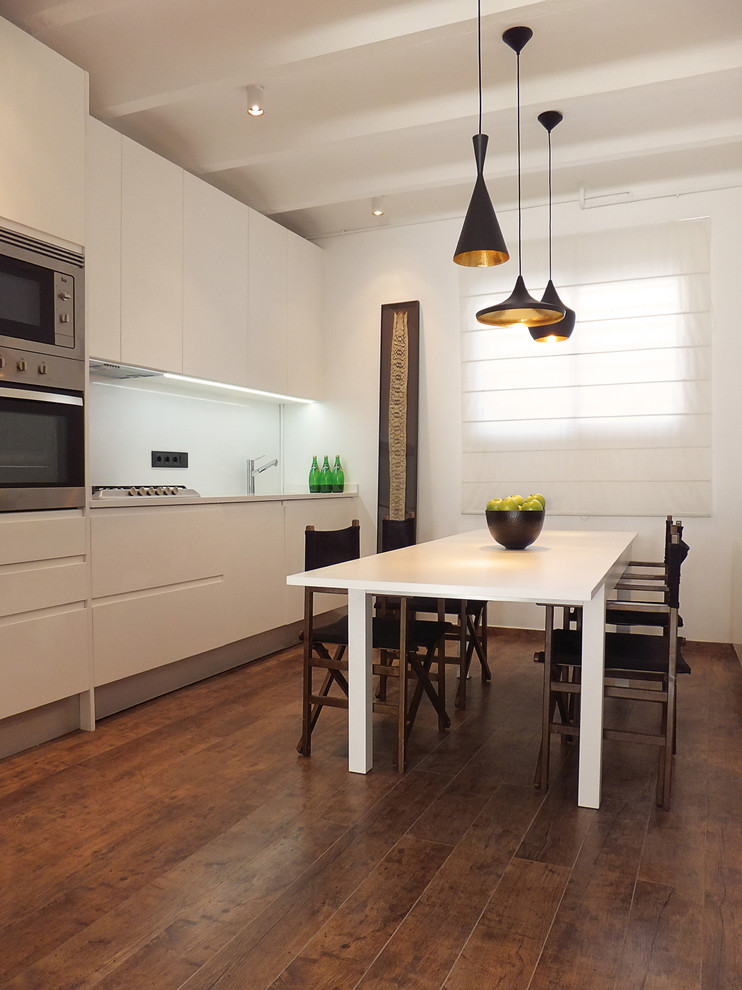 Cette photo montre une salle à manger ouverte sur la cuisine tendance de taille moyenne avec un mur blanc, parquet foncé et aucune cheminée.