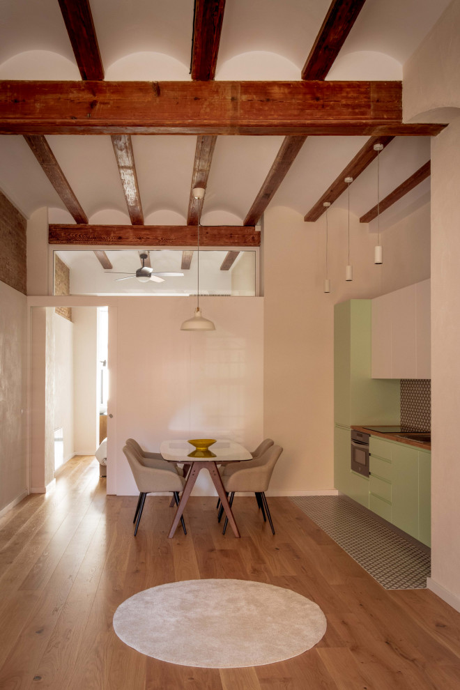Esempio di una sala da pranzo aperta verso la cucina mediterranea di medie dimensioni con pareti bianche e pavimento in legno massello medio
