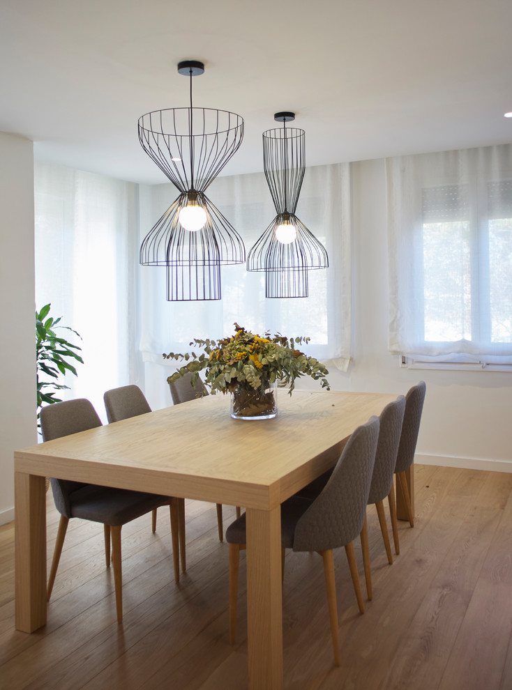 Diseño de comedor escandinavo grande abierto con paredes blancas y suelo de madera en tonos medios