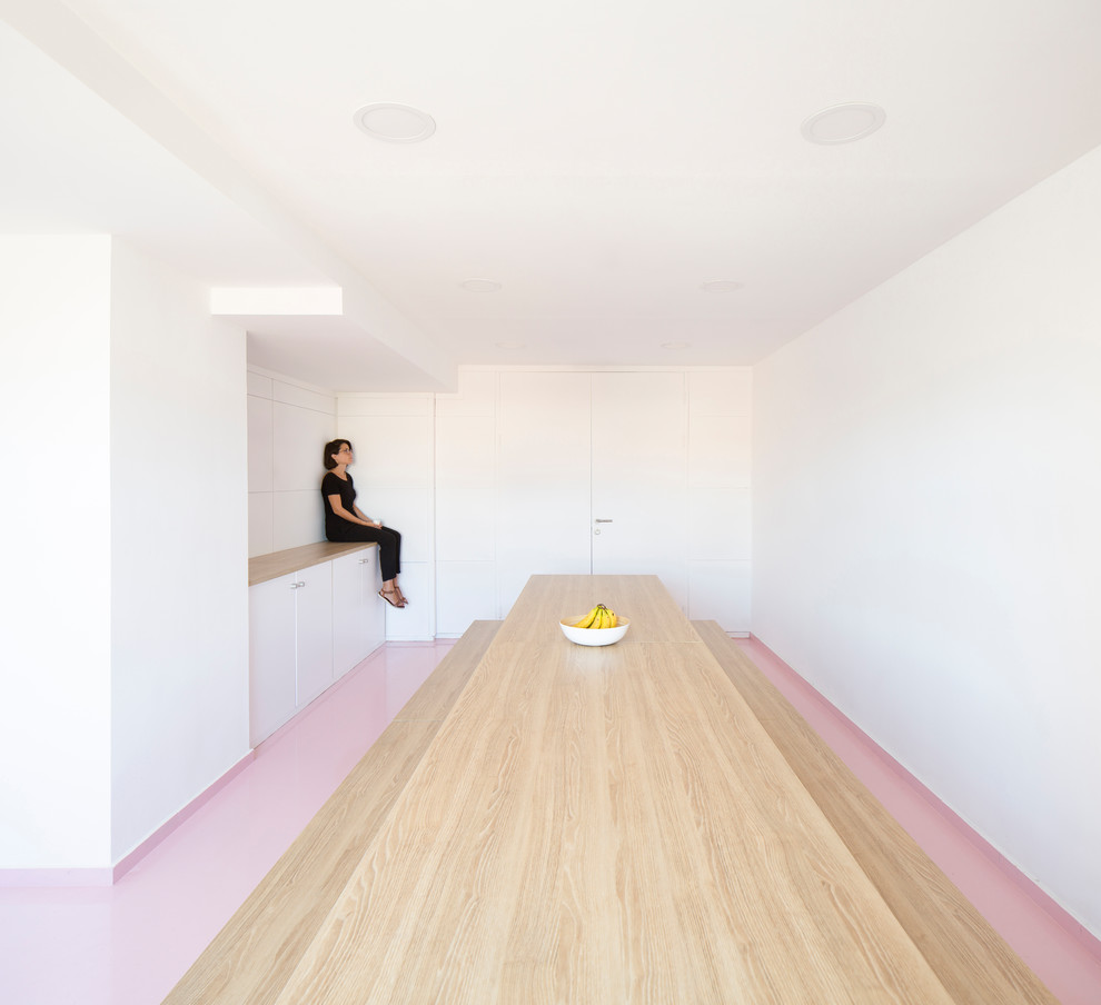 Immagine di una sala da pranzo aperta verso la cucina nordica di medie dimensioni con pareti bianche e pavimento rosa