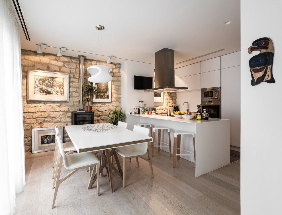 Mittelgroße Moderne Wohnküche mit beiger Wandfarbe, hellem Holzboden, Kaminofen und beigem Boden in Valencia