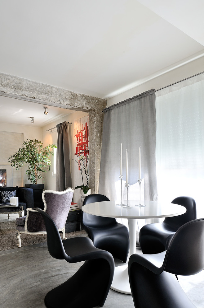 Photo of a small contemporary open plan dining room in Madrid with white walls and concrete flooring.