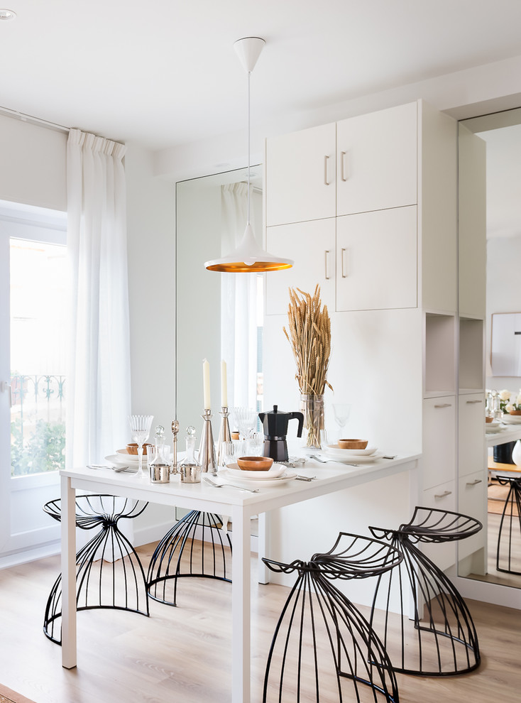 Ispirazione per una piccola sala da pranzo aperta verso la cucina design con pareti bianche, pavimento beige e parquet chiaro
