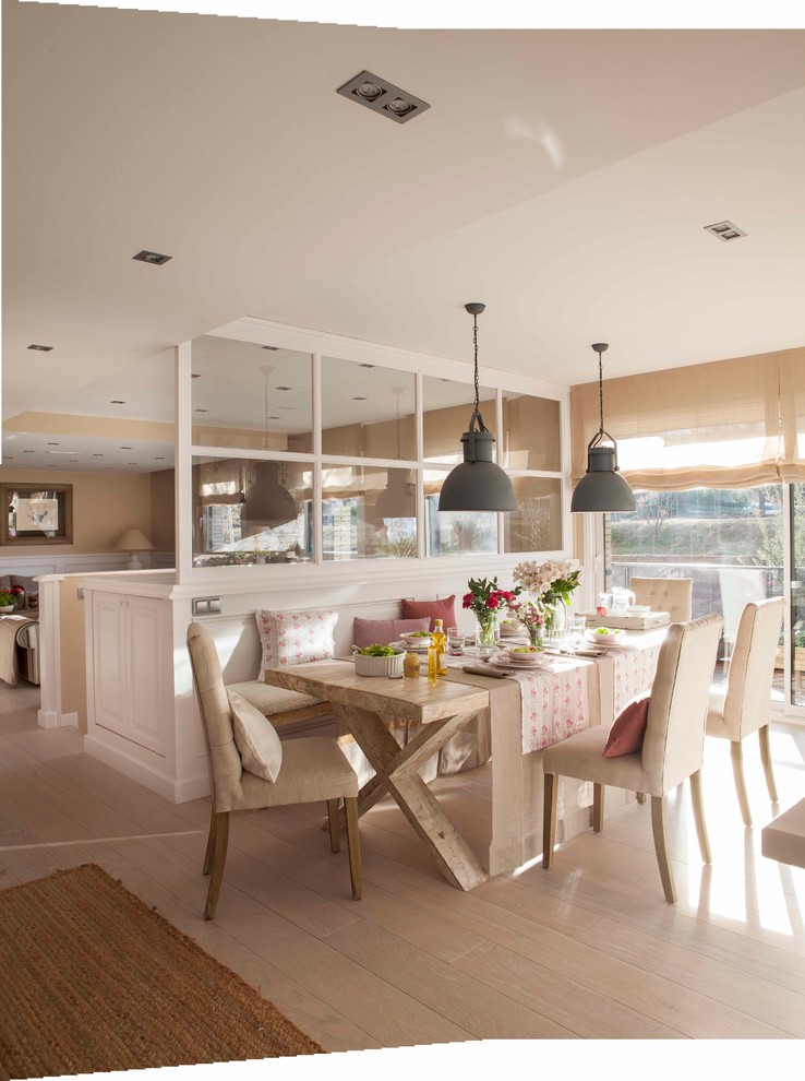 Imagen de comedor campestre de tamaño medio abierto con paredes beige, suelo de madera clara y suelo beige