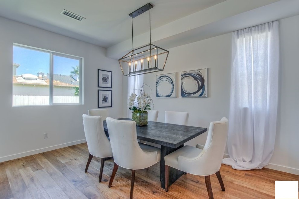 Mittelgroße Moderne Wohnküche mit weißer Wandfarbe, braunem Holzboden, Hängekamin, Kaminumrandung aus Metall und braunem Boden in Los Angeles