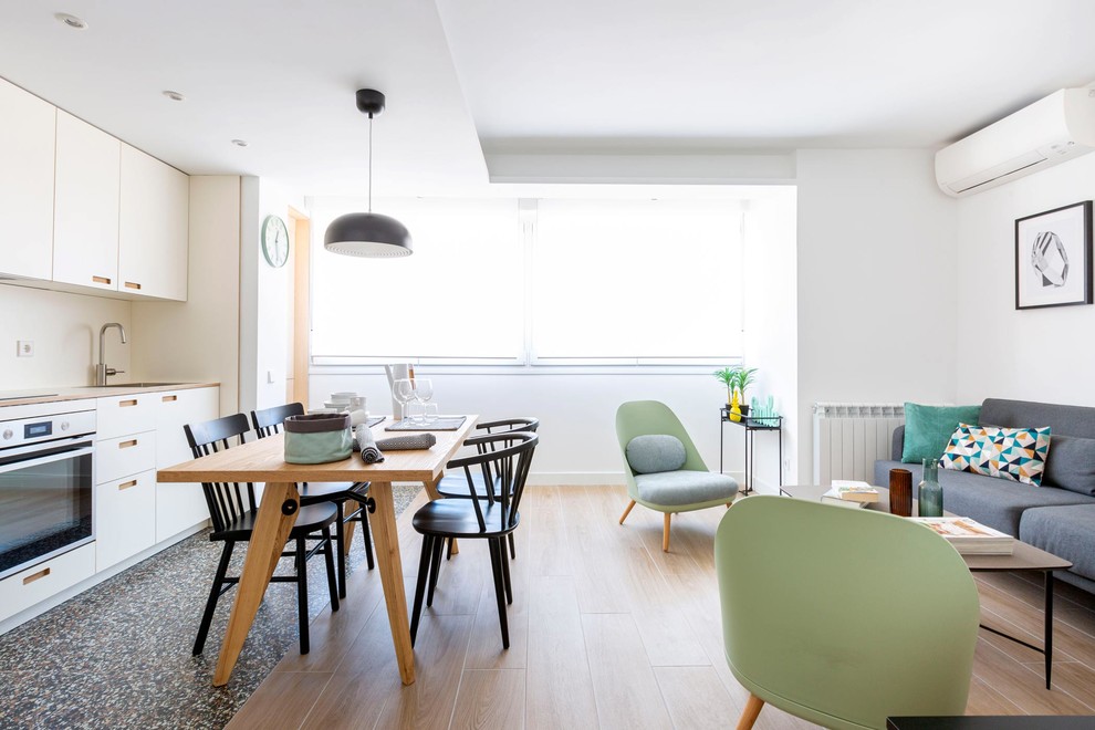 Inspiration pour une salle à manger ouverte sur le salon design avec un mur blanc, parquet clair et un sol beige.