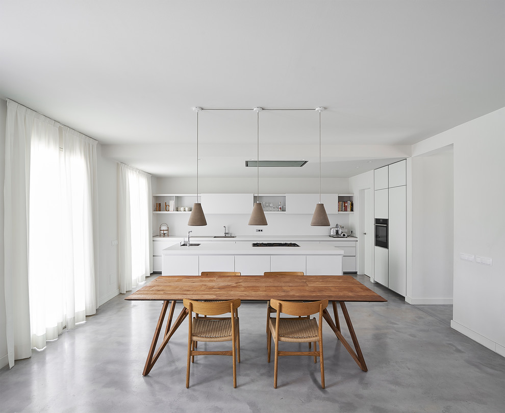 Inspiration pour une grande salle à manger ouverte sur la cuisine méditerranéenne avec un mur blanc, sol en béton ciré et un sol gris.