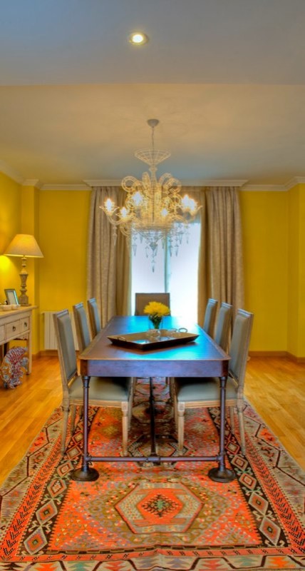 Стильный дизайн: гостиная-столовая среднего размера в стиле неоклассика (современная классика) с желтыми стенами и паркетным полом среднего тона без камина - последний тренд