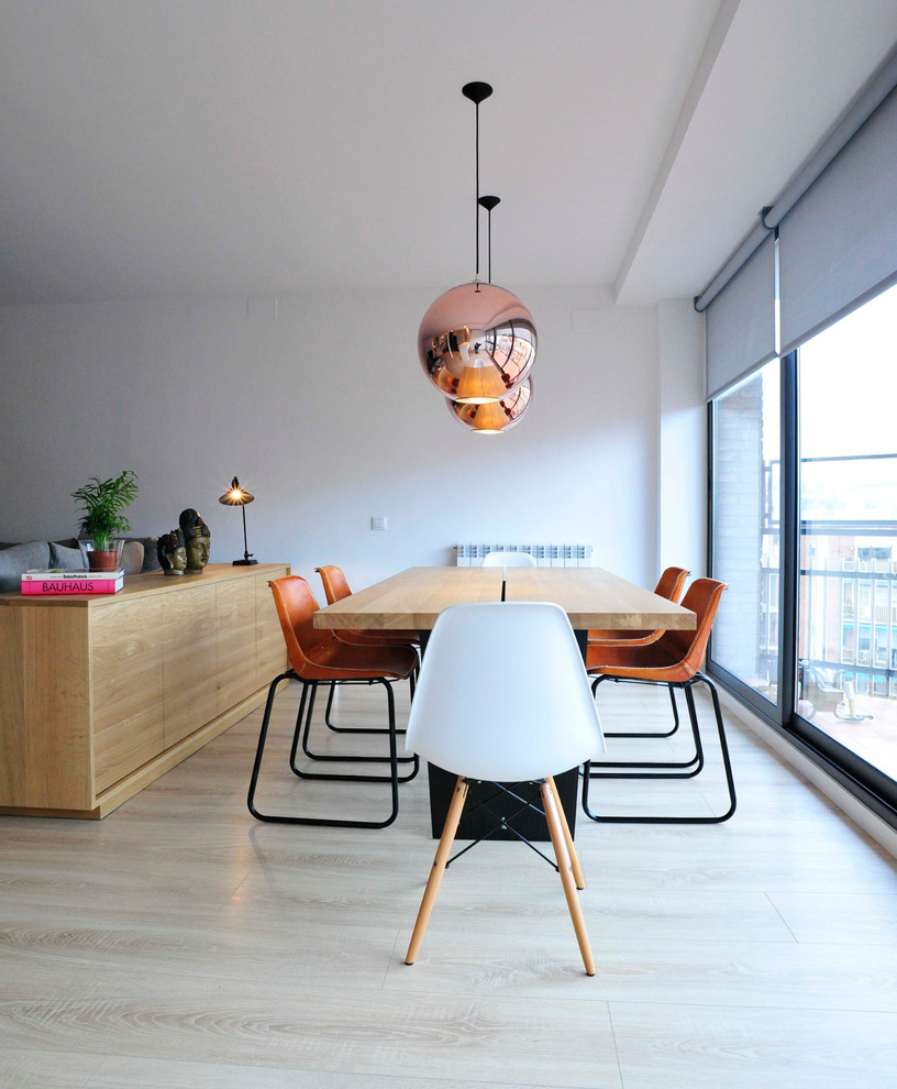 Photo of a large contemporary dining room in Barcelona with white walls, light hardwood flooring and no fireplace.