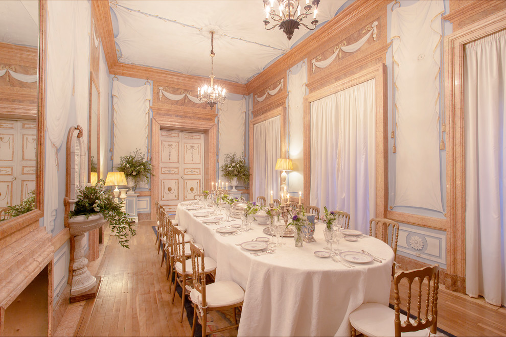 Idee per un'ampia sala da pranzo classica chiusa con pareti multicolore, pavimento in legno massello medio e camino classico