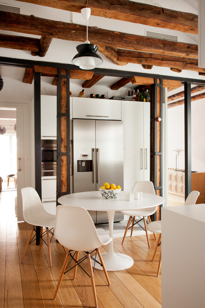 Foto de comedor de cocina bohemio de tamaño medio sin chimenea con paredes blancas y suelo de madera en tonos medios