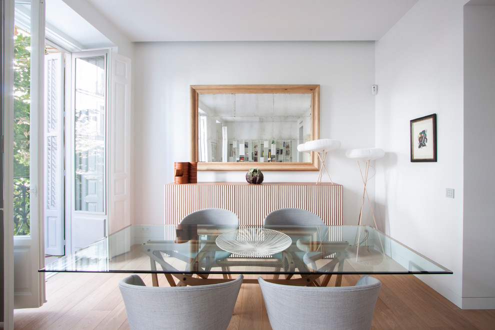 Foto de comedor minimalista de tamaño medio cerrado con paredes blancas y suelo de madera clara