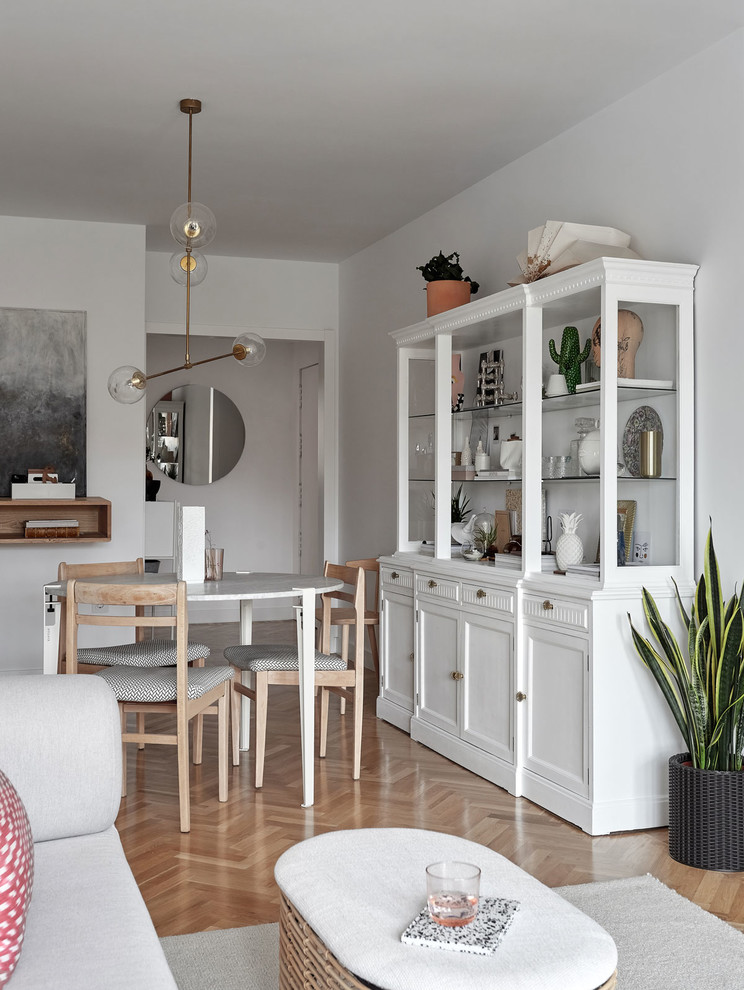 Imagen de comedor escandinavo de tamaño medio abierto sin chimenea con paredes blancas, suelo de madera en tonos medios y suelo marrón