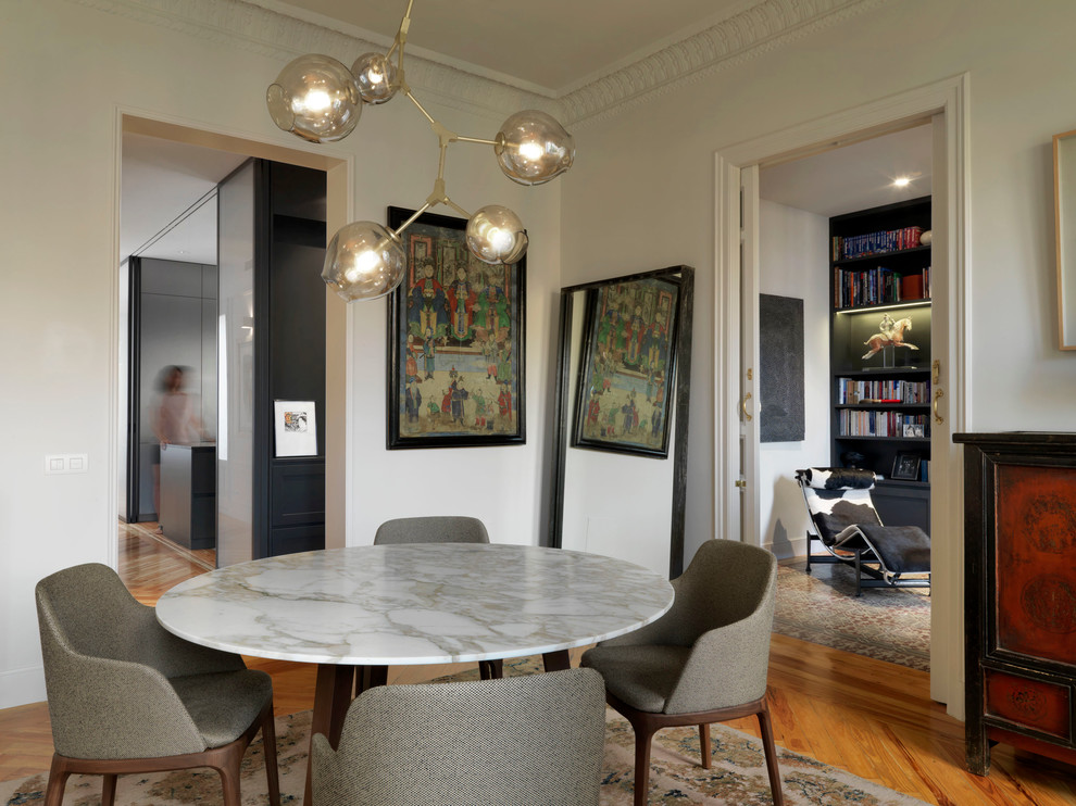 Ispirazione per una piccola sala da pranzo aperta verso il soggiorno con pareti bianche e pavimento in legno massello medio
