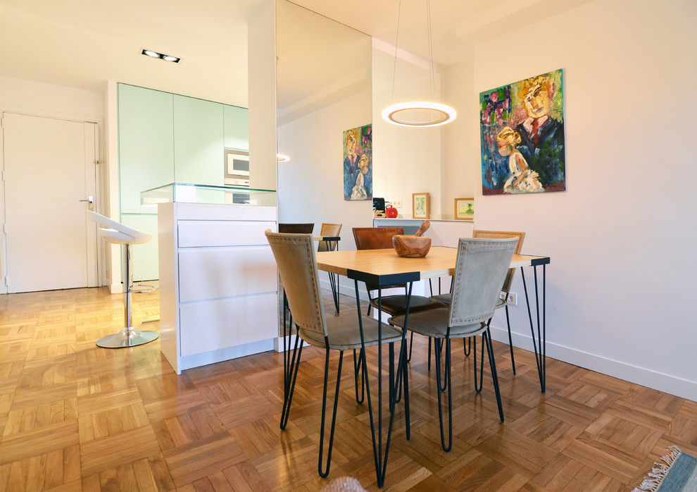 Example of a mid-sized trendy medium tone wood floor and brown floor dining room design in Madrid with white walls