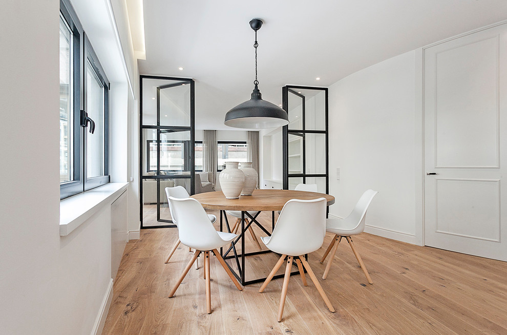 Ispirazione per una sala da pranzo scandinava chiusa e di medie dimensioni con pareti bianche, pavimento in legno massello medio e pavimento marrone