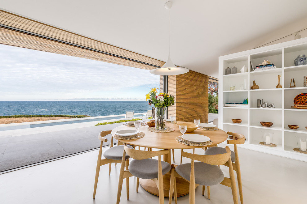 Idee per una sala da pranzo aperta verso la cucina stile marinaro con pareti marroni e pavimento beige