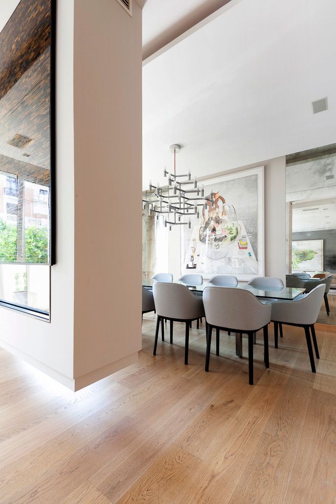 Immagine di una sala da pranzo aperta verso il soggiorno moderna di medie dimensioni con pareti beige, pavimento in legno massello medio e nessun camino