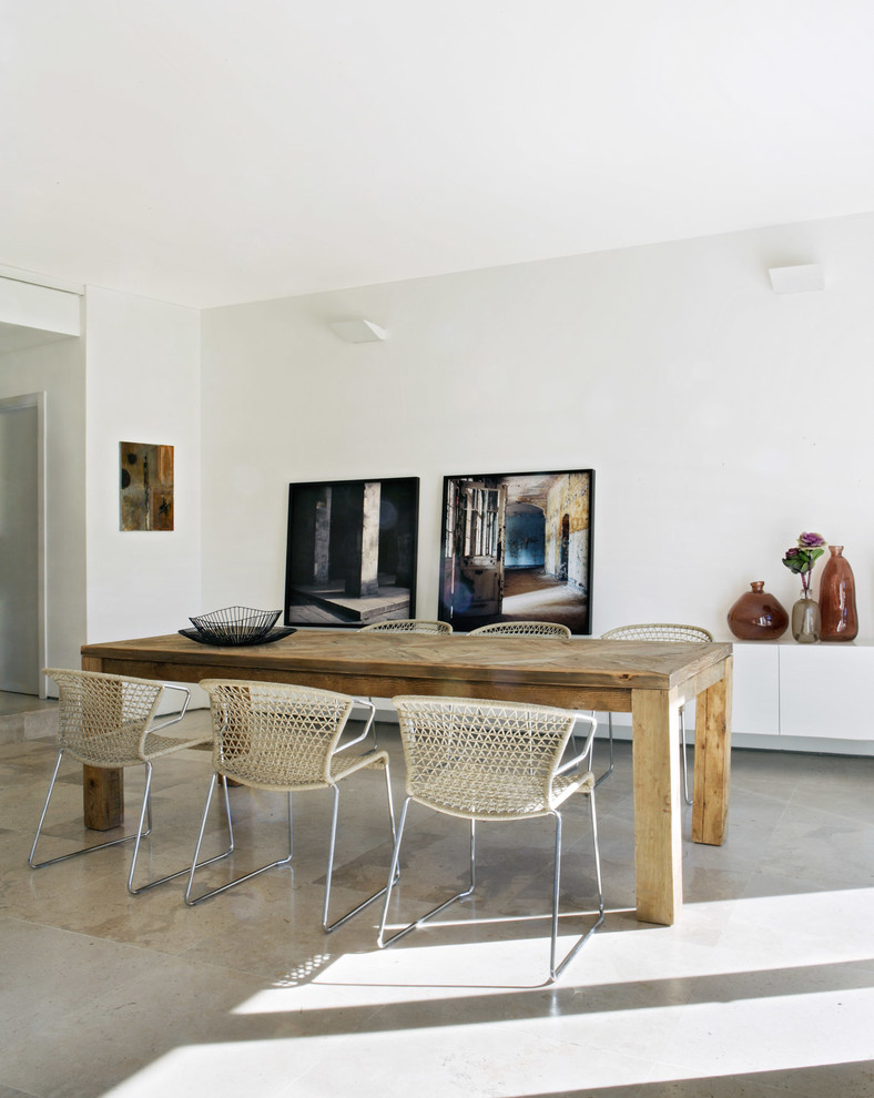 На фото: гостиная-столовая среднего размера в современном стиле с белыми стенами и полом из известняка без камина с