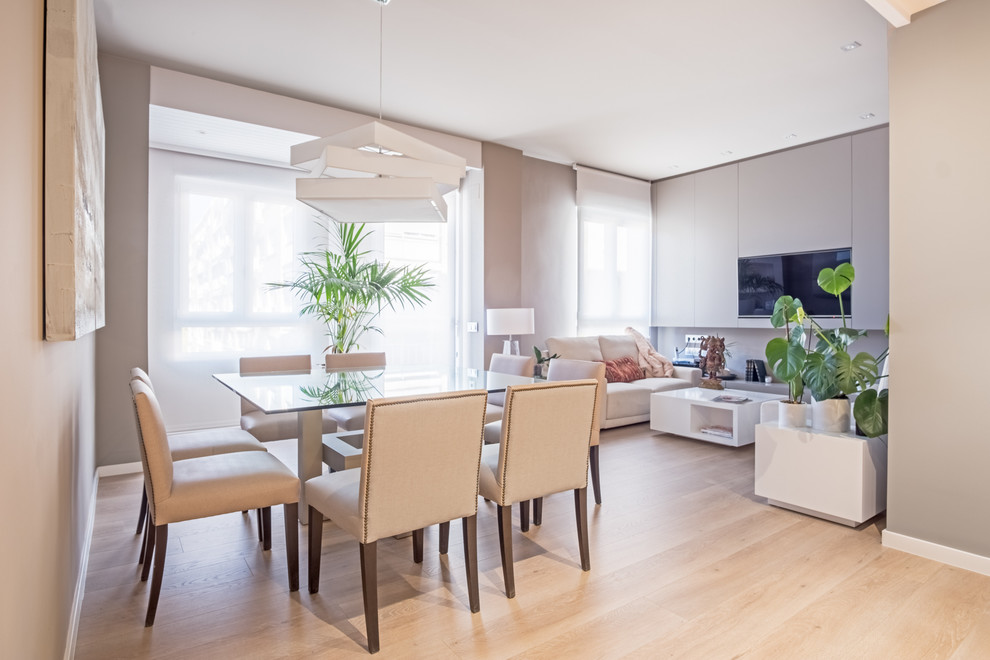 Photo of a modern dining room in Madrid with grey walls and laminate floors.