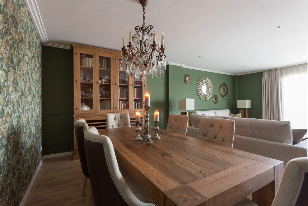 Exemple d'une salle à manger ouverte sur le salon chic de taille moyenne avec un mur vert, parquet clair, cheminée suspendue, un manteau de cheminée en bois et un sol beige.