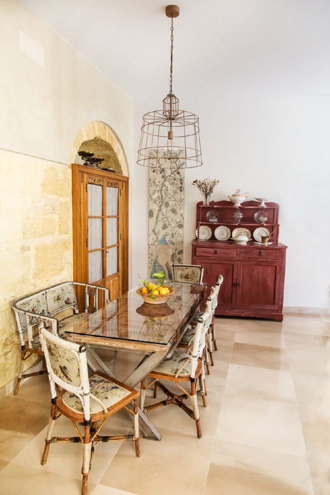 Cette photo montre une salle à manger méditerranéenne avec un mur blanc, aucune cheminée et un sol beige.