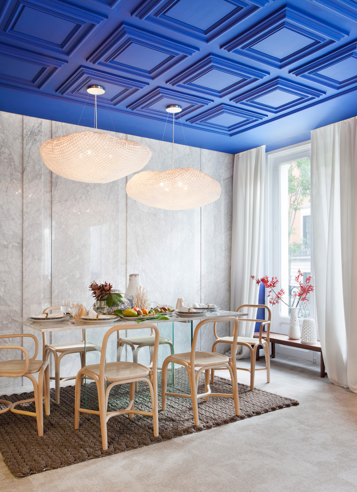 На фото: большая гостиная-столовая в средиземноморском стиле с серыми стенами и бетонным полом без камина с