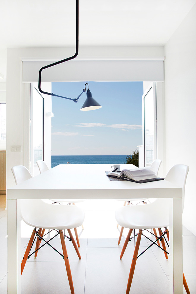 Immagine di una piccola sala da pranzo aperta verso il soggiorno mediterranea con pareti bianche, pavimento con piastrelle in ceramica e nessun camino