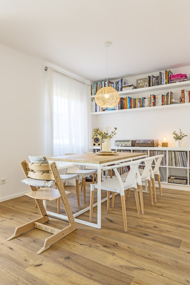 Idée de décoration pour une salle à manger ouverte sur le salon design avec un mur blanc, un sol en bois brun et un sol marron.