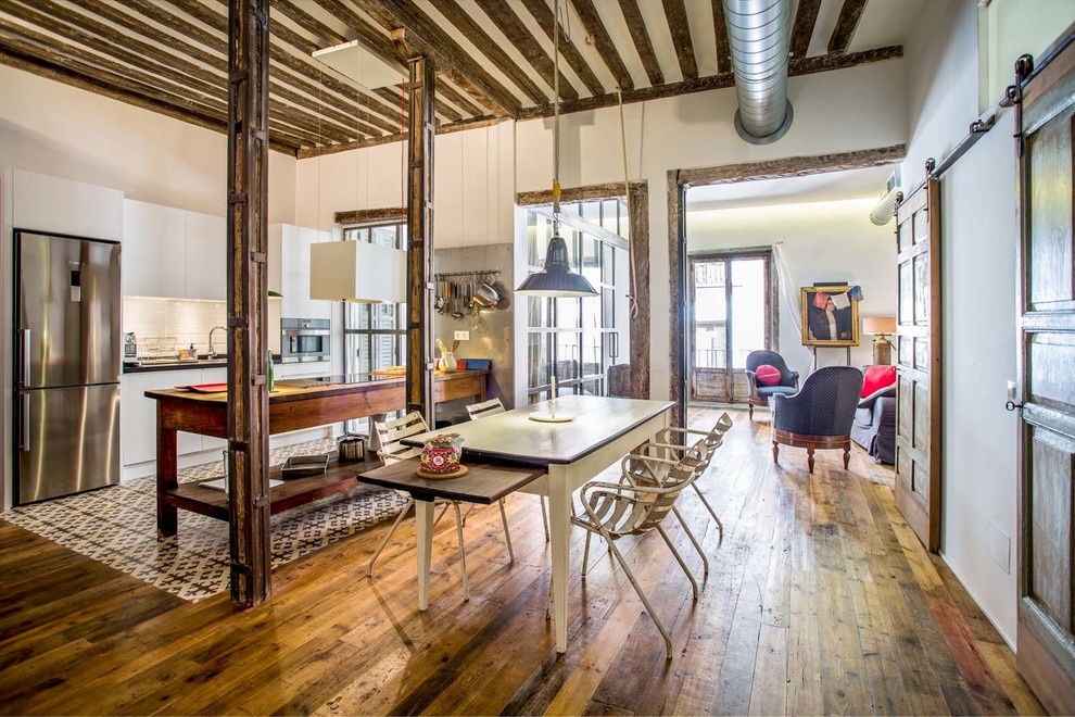 Idée de décoration pour une grande salle à manger ouverte sur le salon urbaine avec un mur blanc, un sol en bois brun et aucune cheminée.