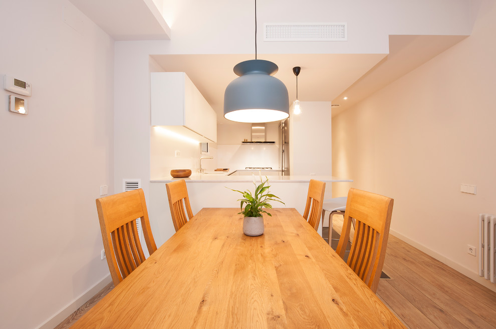 Ejemplo de comedor minimalista de tamaño medio abierto sin chimenea con paredes blancas, suelo de madera en tonos medios y suelo marrón