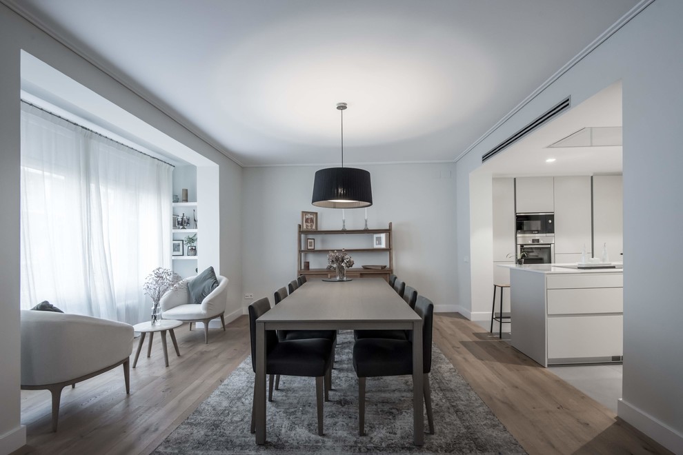 Inspiration for a contemporary medium tone wood floor and brown floor kitchen/dining room combo remodel in Barcelona with white walls