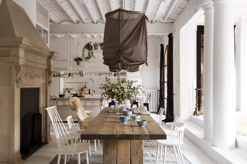 Modelo de comedor de cocina romántico grande con paredes blancas, suelo de madera pintada y todas las chimeneas