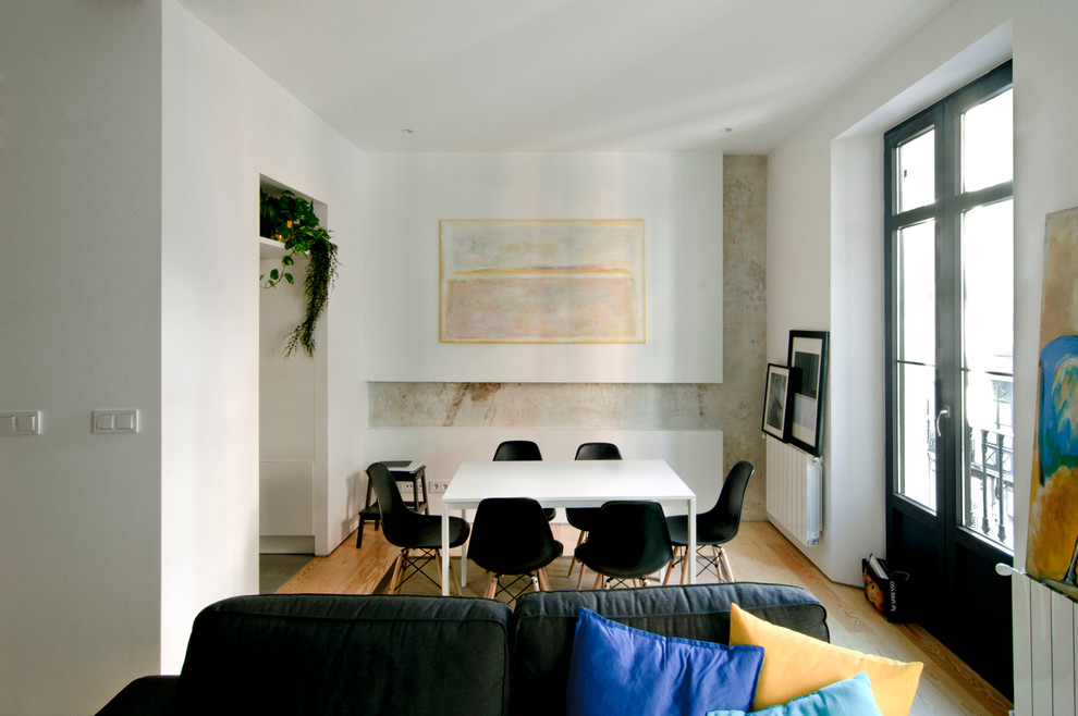 Cette photo montre une petite salle à manger ouverte sur le salon chic avec un mur blanc, parquet clair et aucune cheminée.