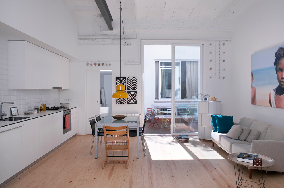 Offenes, Mittelgroßes Industrial Esszimmer ohne Kamin mit weißer Wandfarbe und hellem Holzboden in Barcelona