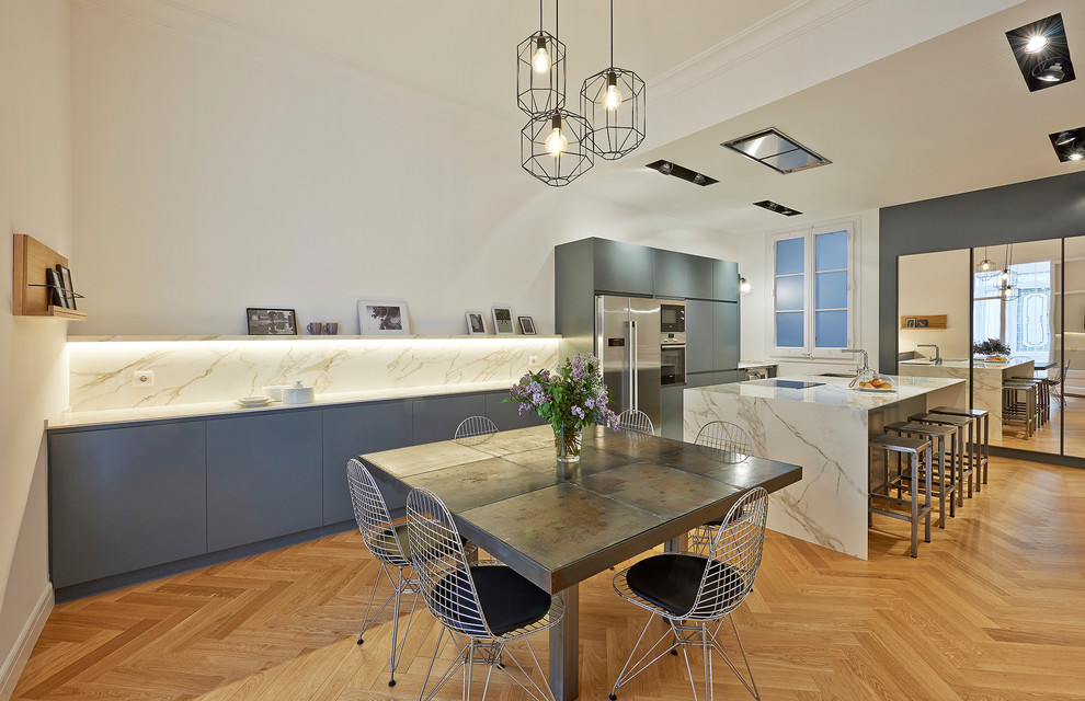 Inspiration pour une grande salle à manger ouverte sur la cuisine design avec un mur blanc et parquet clair.