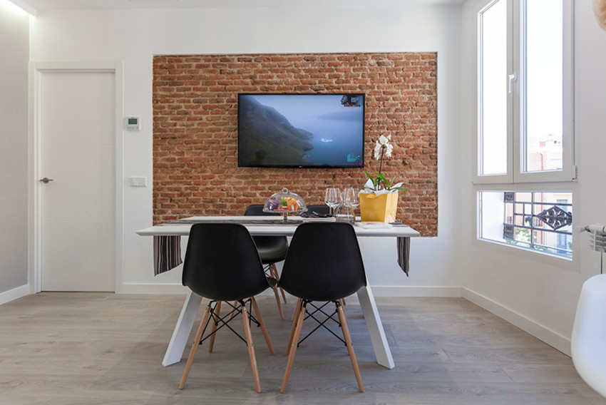 Immagine di una sala da pranzo aperta verso il soggiorno minimal di medie dimensioni con pareti bianche, pavimento in laminato e pavimento grigio