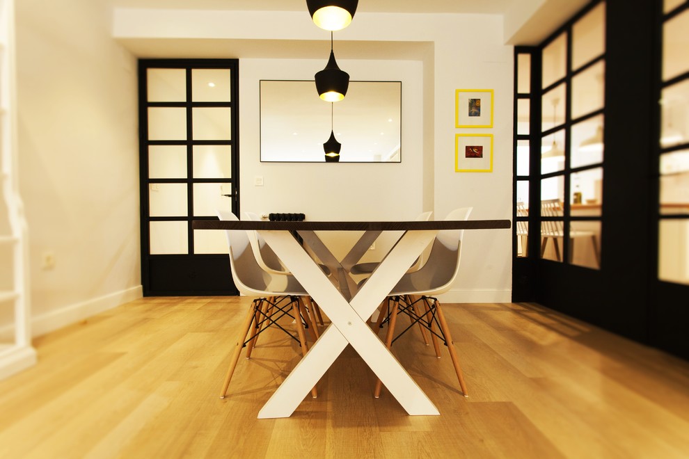 Imagen de comedor actual de tamaño medio cerrado sin chimenea con paredes blancas y suelo de madera en tonos medios