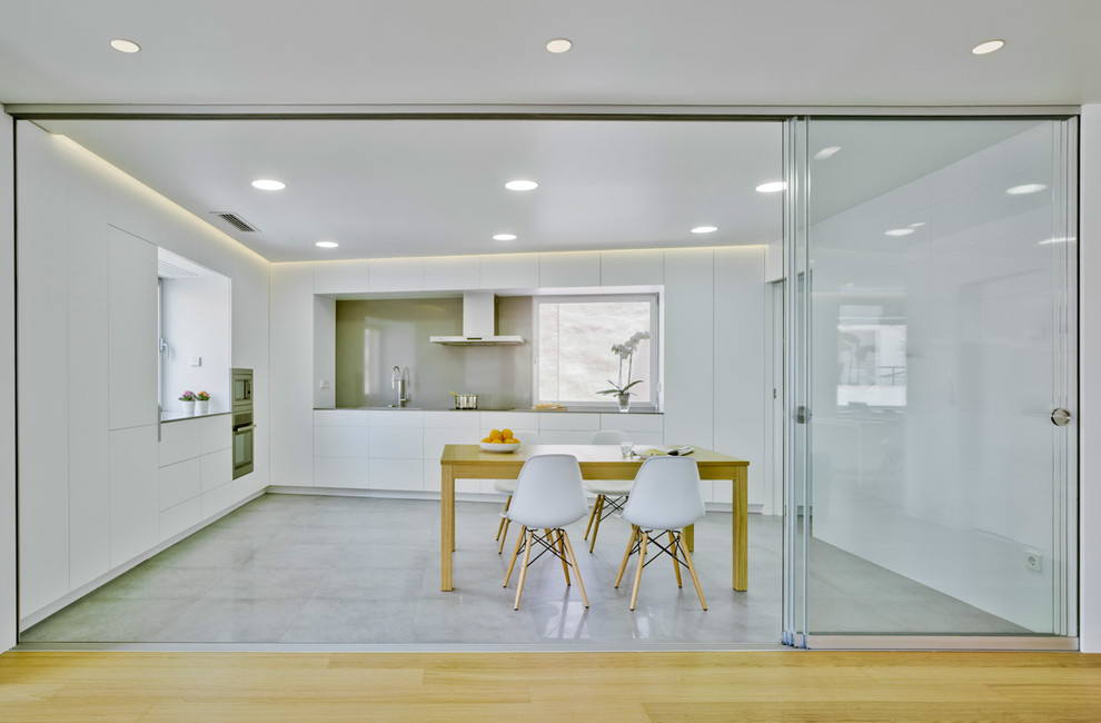 Idee per una sala da pranzo aperta verso la cucina design con pareti bianche