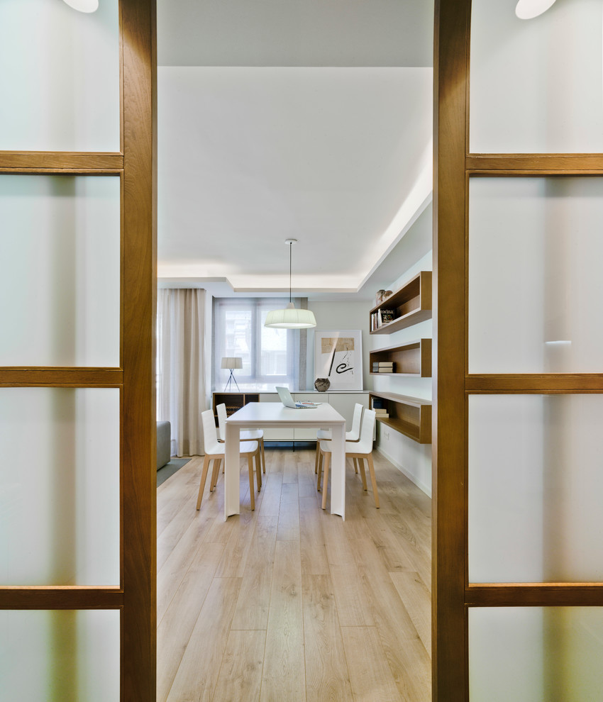 Esempio di una sala da pranzo aperta verso il soggiorno minimal di medie dimensioni con pareti bianche, pavimento in legno massello medio e nessun camino