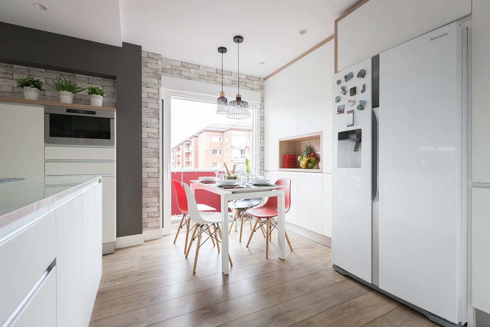 Esempio di una sala da pranzo aperta verso la cucina contemporanea di medie dimensioni con pareti bianche, pavimento in legno massello medio e pavimento marrone