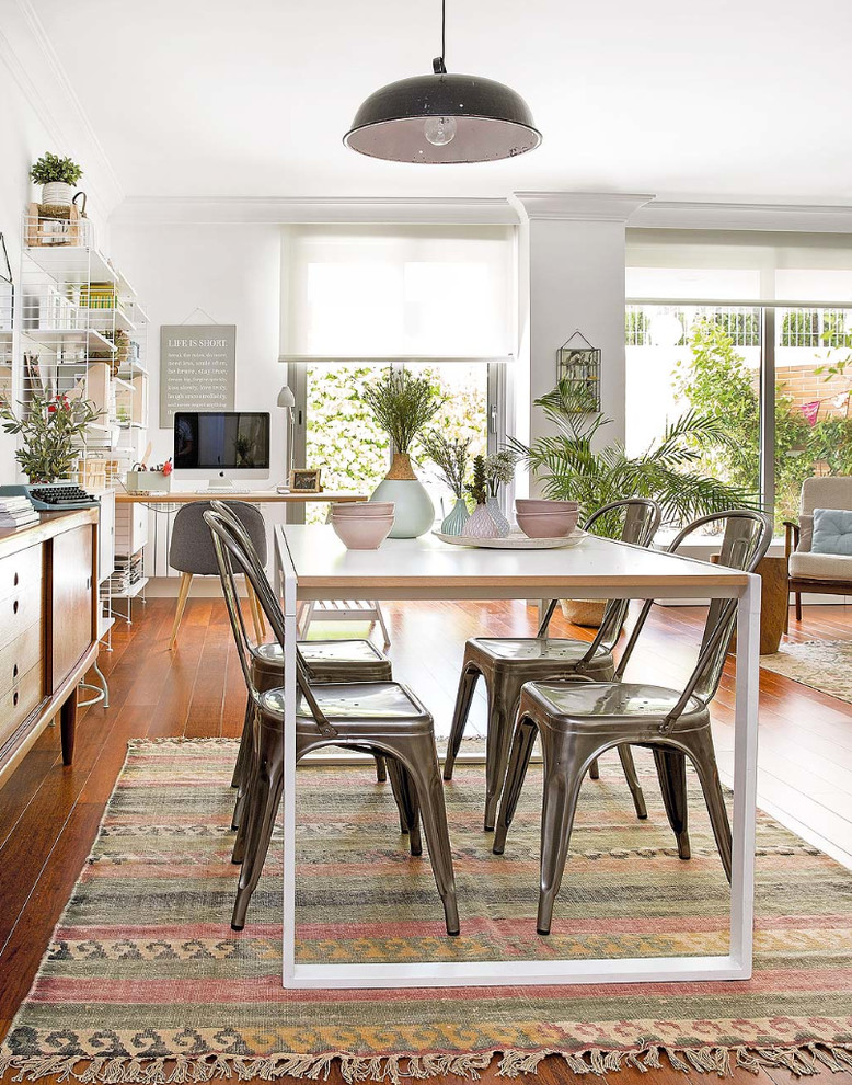 Immagine di una sala da pranzo aperta verso il soggiorno scandinava di medie dimensioni con pareti bianche, parquet scuro e nessun camino