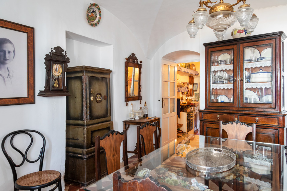Imagen de comedor de cocina abovedado rústico de tamaño medio con paredes blancas y suelo de baldosas de cerámica